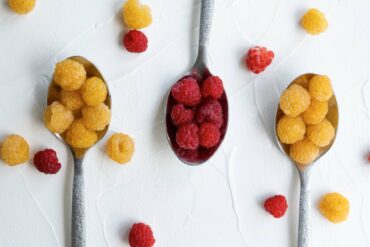 Gold raspberries and red raspberries on a spoon.
